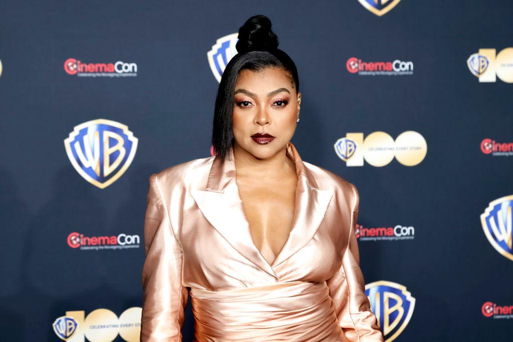 Tarahi P. Henson wears a satin dress and maroon lipstick on the red carpet of CinemaCon.