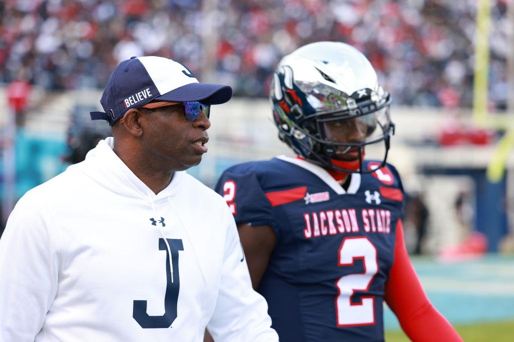 Coach Deion Sanders talks with JSU quarterback Shedeur Sanders during the Jackson State Tigers and Southern University Jaguars SWAC Football Championship game 