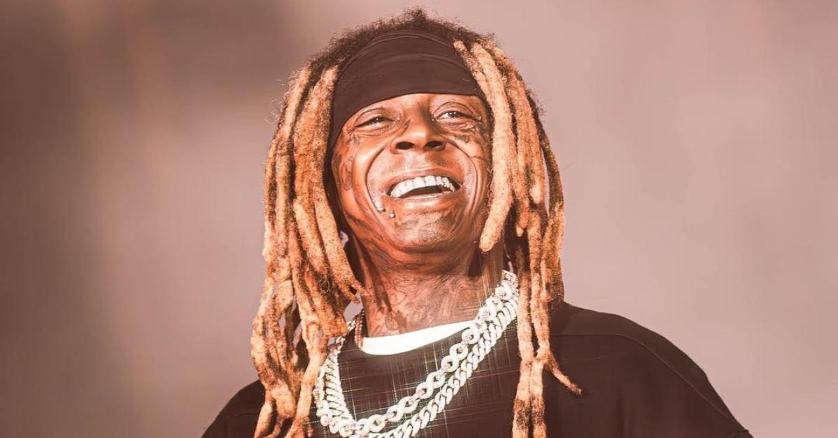 Lil Wayne smiles on stage.