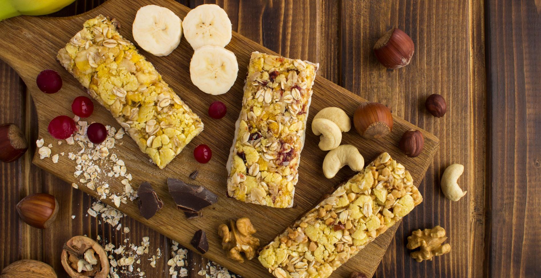 energy protein bars with different ingredient on the cutting board on the brown wooden