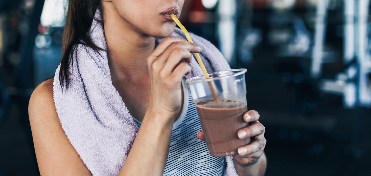 woman drinks protein shake in the gym