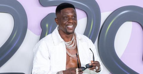 Boosie Badazz with silver chains and white jacket smiling at the camera