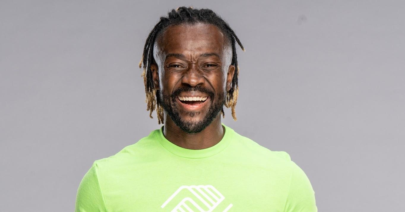 Kofi Kingston smiles wearing a lime green Boys and Girls Clubs shirt.