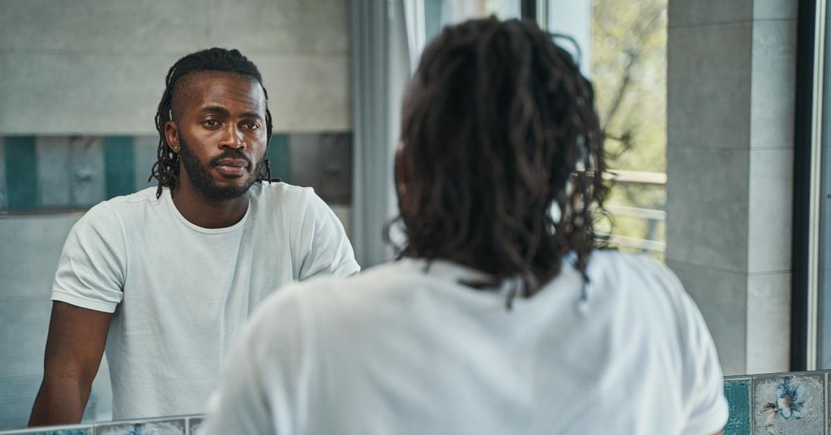 black man looking at his reflection in the mirror