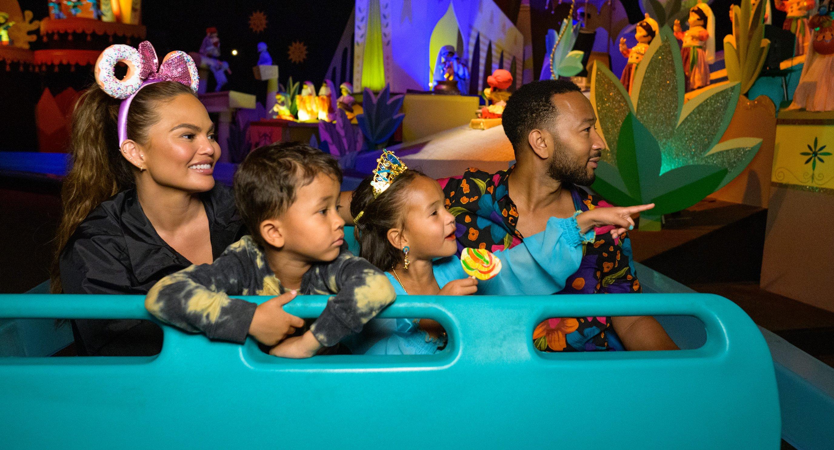 chrissy teigen john legend and their children miles and luna ride on its a small world