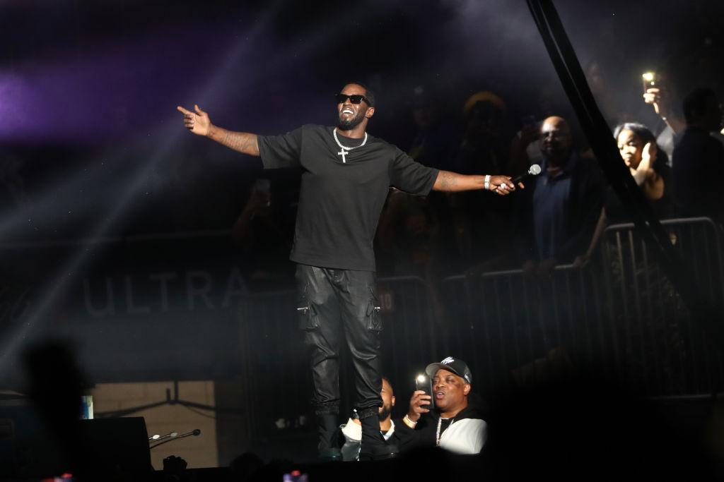 P.Diddy smiles and performs on stage in all black.