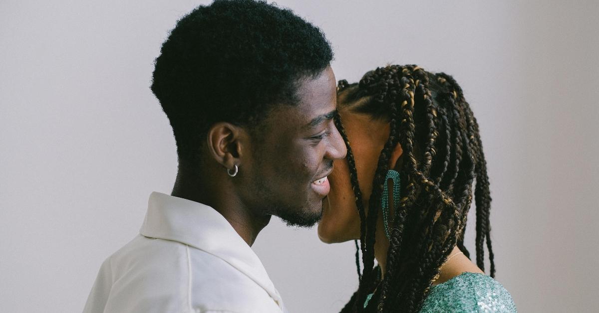 A Black couple smiles and gets close.