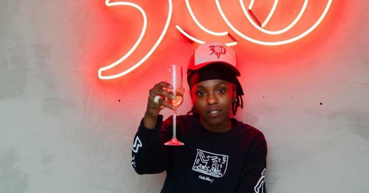 Kenya Vaughn sits in front of a neon 300 sign.