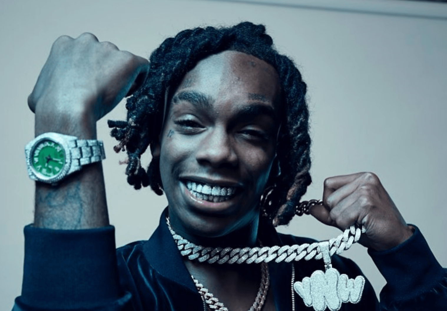 Still shot of YNW Melly holding up iced out watch