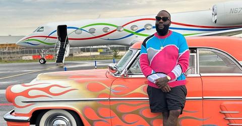 Rick Ross posing in front of private plane
