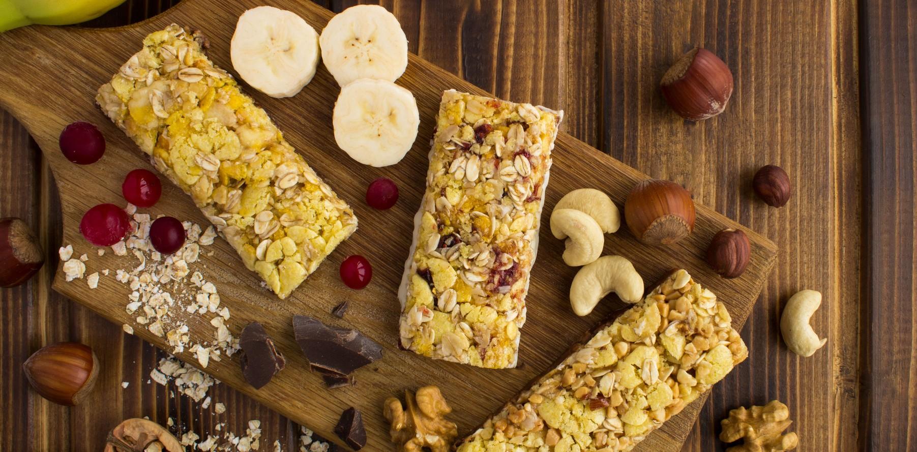 energy candy bars with different ingredient on the cutting board