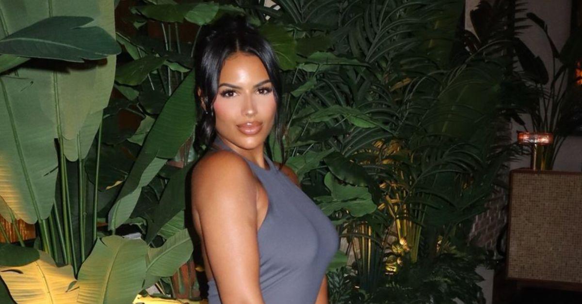 Chaney Jones poses for a photo in front of plants at an event