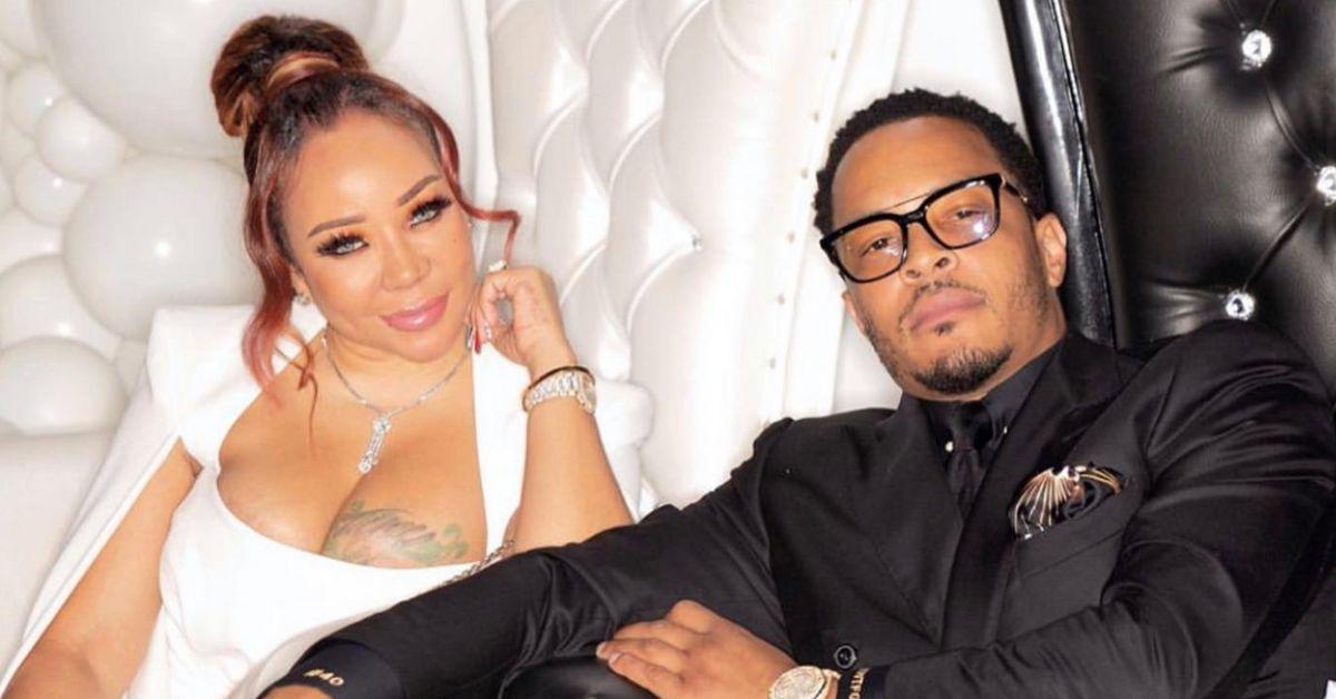 Tiny and T.I. pose for a photo together while seated on black and white chairs