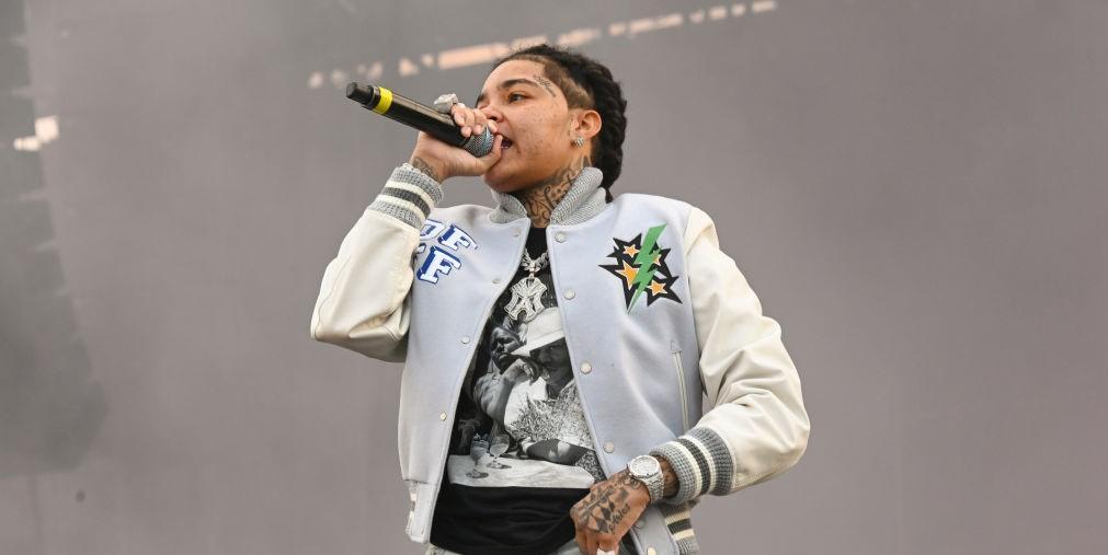 young ma on stage holding black microphone