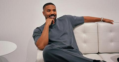 Michael B. Jordan sits on a white coach.