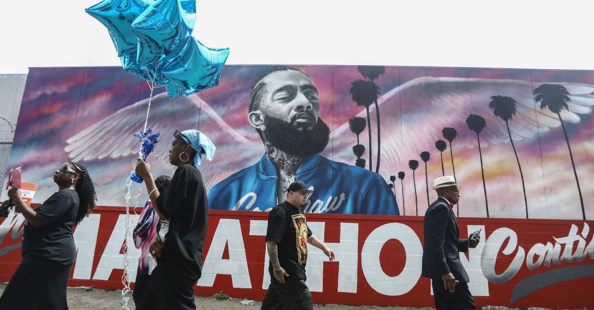 Fans walk as they wait outside The Marathon Clothing store for the funeral procession for slain rapper Nipsey Hussle.