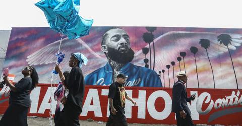 Fans walk as they wait outside The Marathon Clothing store for the funeral procession for slain rapper Nipsey Hussle.