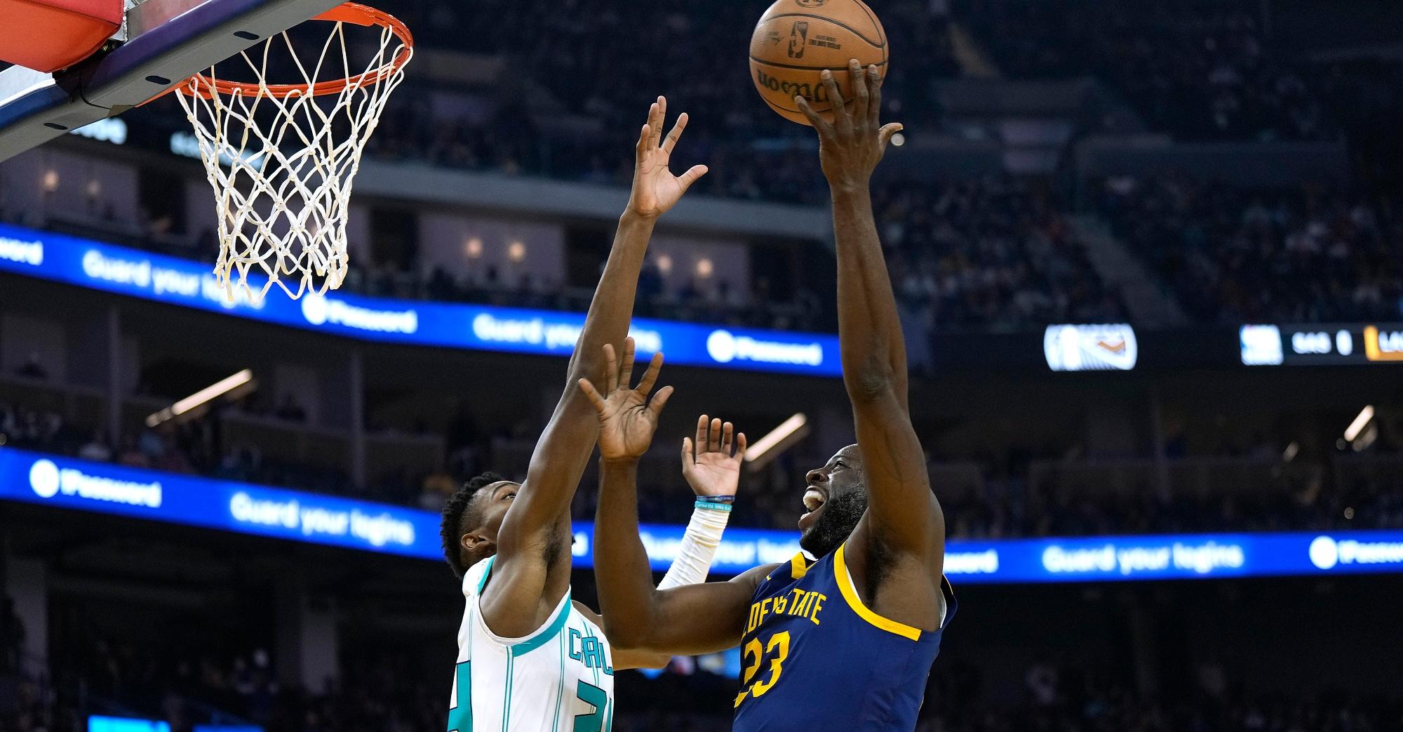 draymond green  of the golden state warriors shoots over brandon miller