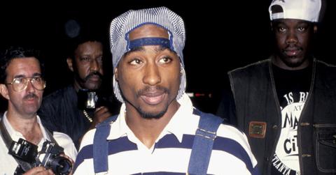 Tupac wears long sleeve shirt, overalls, and a blue and white hat at the Wiltern theater in Los Angeles.