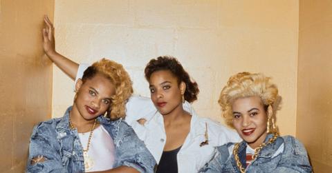 American hip hop band Salt-n-Pepa (Jamaican-American rapper Pepa, American DJ Spinderella, and American rapper Salt), with Pepa and Salt wearing denim jackets with their arms folded, in a studio portrait, United States, circa 1990.