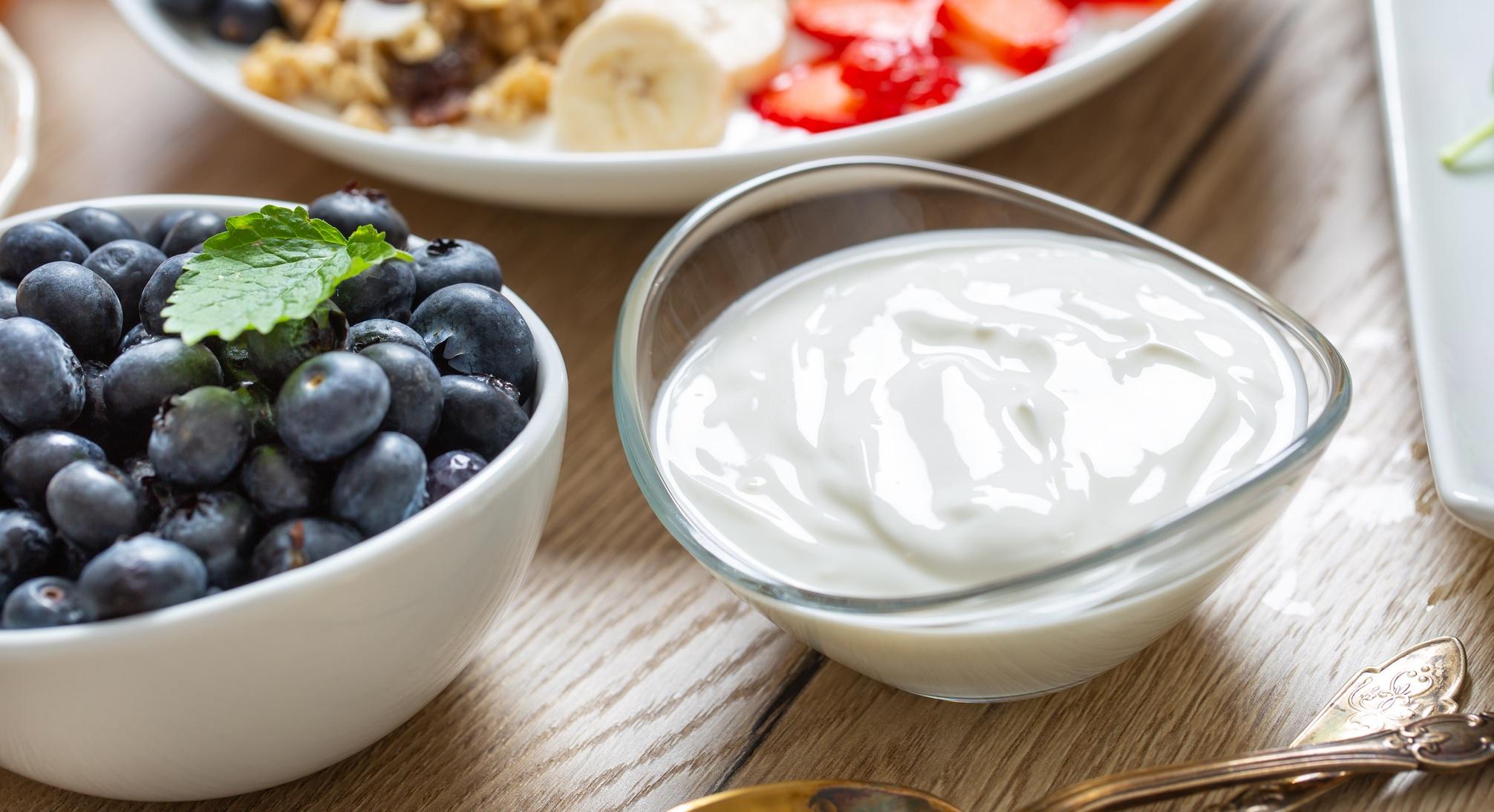 yogurt in a glass bowl with healthy breakfast on table