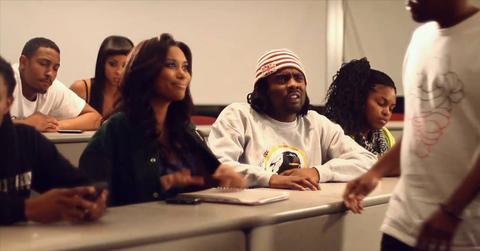 Wale sits in a classroom in the video for "The Breakup Song".