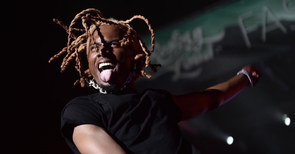 Playboi Carti performs during the 2019 Rolling Loud music festival wearing a black shirt with his tongue out.