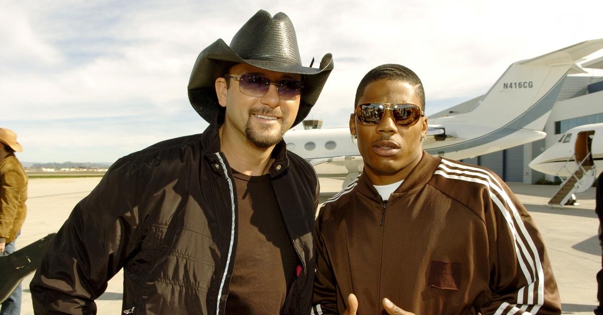 Nelly and Tim McGraw stand side-by-side in front of a private jet on the set of a Budweiser commercial.