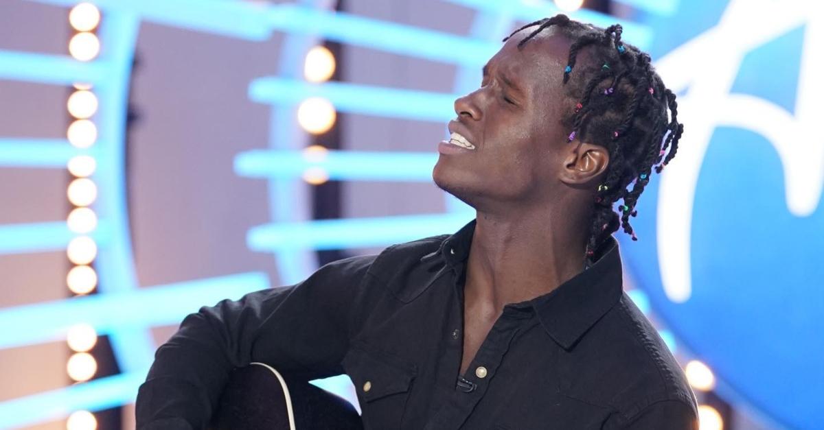 Maurice the music wears black button down shirt and plays guitar and sings on 'American Idol.'