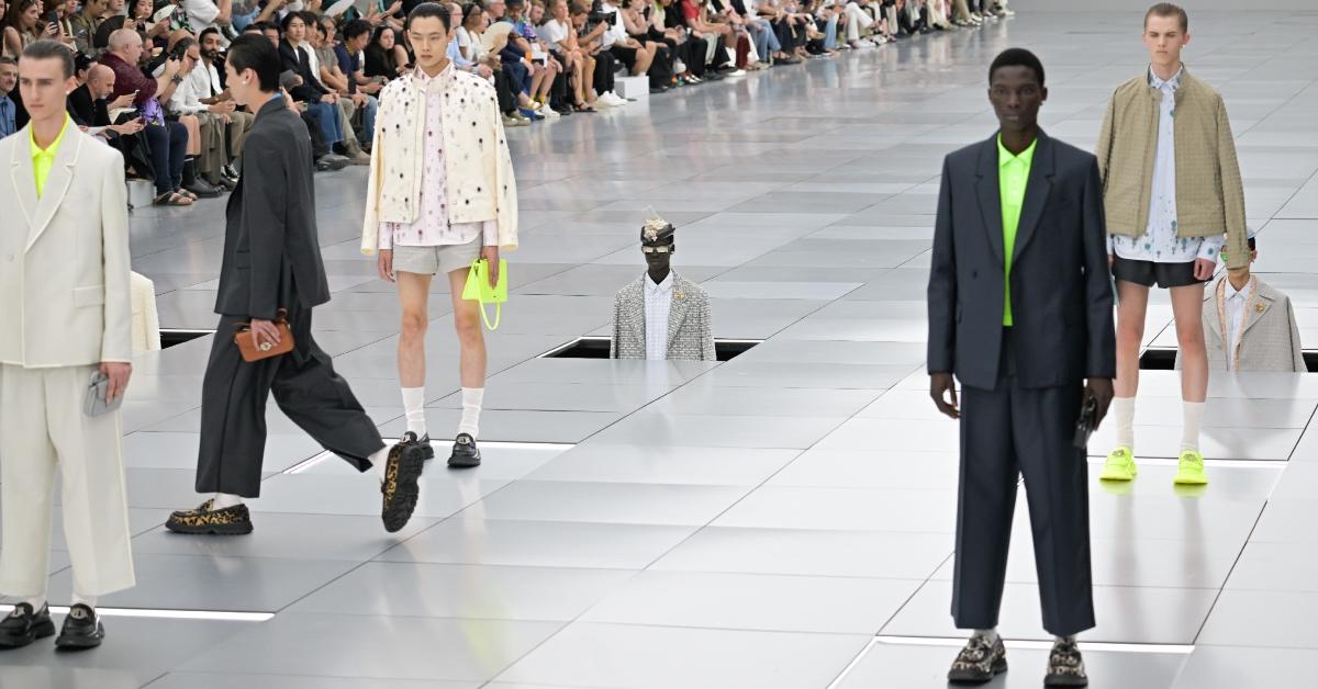 Models walk while others are lowered into the runway during the Dior Homme Menswear Spring/Summer 2024 show.