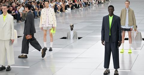 Models walk while others are lowered into the runway during the Dior Homme Menswear Spring/Summer 2024 show.