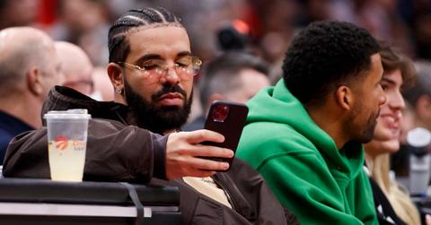 Rapper Drake texts while watching Game Six of the Eastern Conference First Round between the Toronto Raptors and the Philadelphia 76ers at Scotiabank Arena on April 28, 2022 in Toronto, Canada.