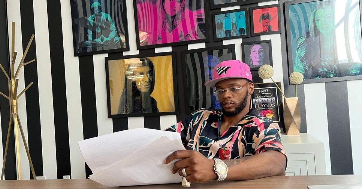 Papoose wears a pink hat and printed button down shirt at TuneCore's headquarters. 