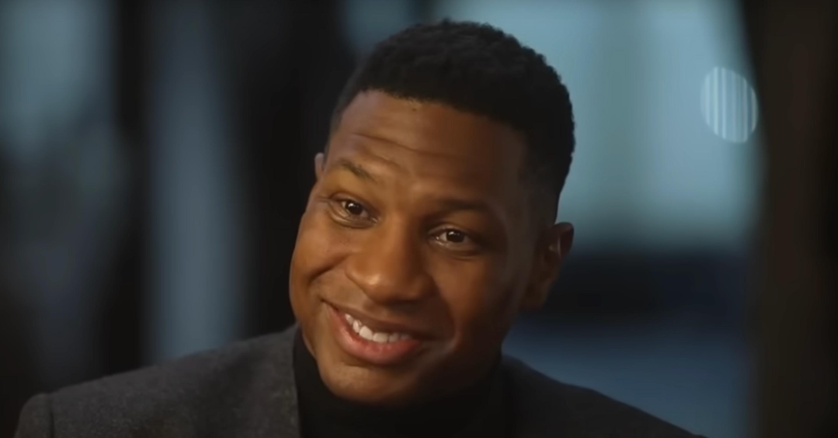 Jonathan Majors smiles in ABC News interview.