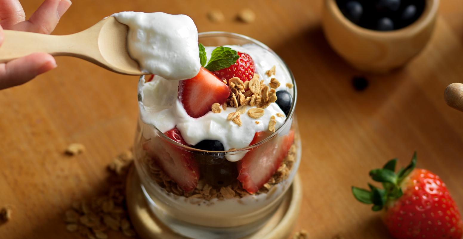 granola with greek yogurt and fresh berries on a glass